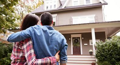 Couple standing in front of New house